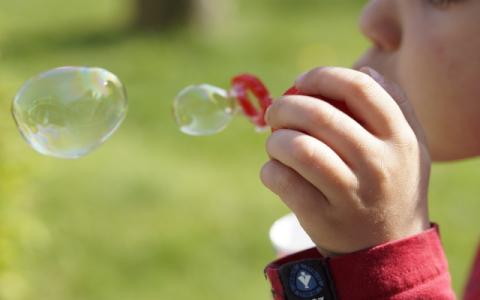 bambino che gioca con le bolle di sapone