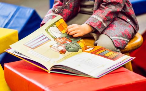bambina che legge un libro per evocare il tema della promozione della lettura nella prima infanzia al centro dell'edizione 2023 del bando Leggimi 0-6