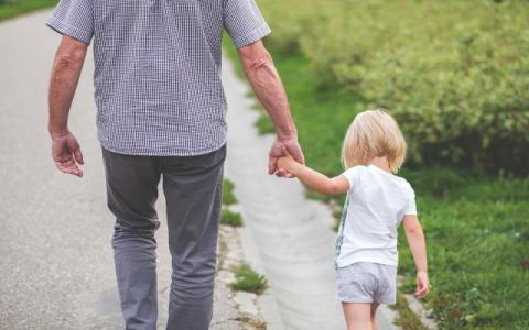 adulto che tiene per mano una bambina per evocare il tema dell'affidamento familiare al centro del convegno L’affido familiare allo specchio. Quali sfide per quale futuro?