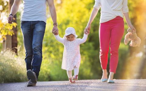 genitori che tengono per mano la figlia piccola per evocare il tema della natalità, al centro del report Istat Indicatori demografici. Anno 2023