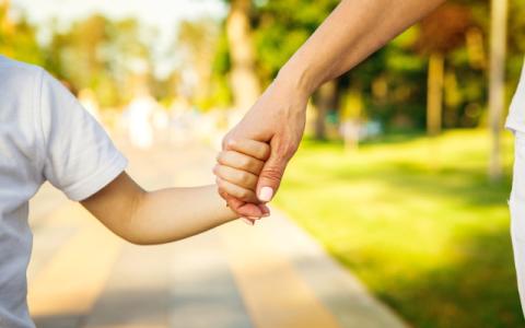 genitore che tiene per mano il figlio