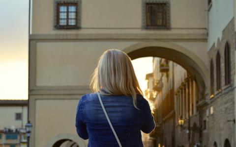 ragazza di spalle di fronte a un edificio