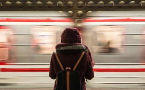 immagine di studentessa che aspetta il treno per evocare il tema dei trasporti per gli studenti pendolari nelle aree urbane sul quale si soffermano i dati dell’Osservatorio #Conibambini