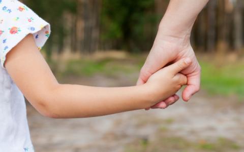 genitore che prende per mano la figlia