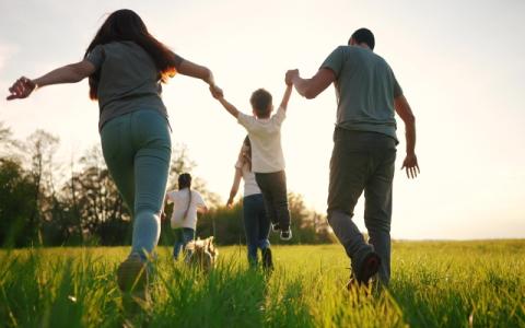 genitori e figli che corrono su un prato