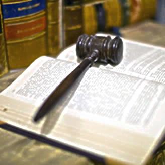martello del giudice adagiato su un codice aperto a simboleggiare l'analisi giuridica