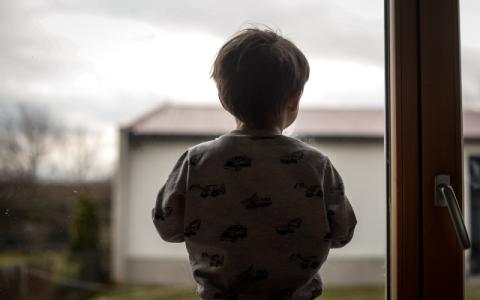 bambino di spalle davanti a una finestra
