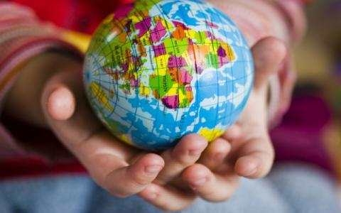 bambino che tiene in mano un piccolo mappamondo