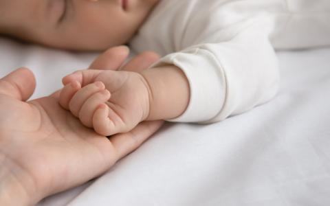 genitore che tocca la mano del figlio neonato