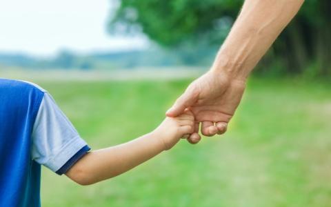 bambino e adulto che si tengono per mano