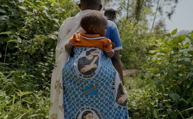 madre africana che porta sulle spalle il proprio bambino