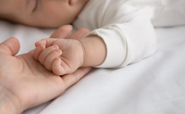 genitore che tocca la mano del figlio neonato