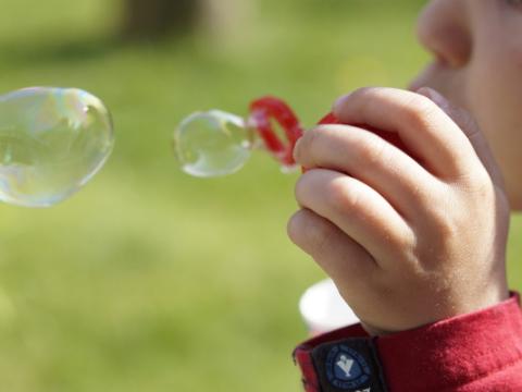 bambino che gioca con le bolle di sapone