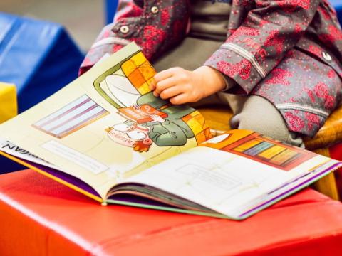 bambina che legge un libro per evocare il tema della promozione della lettura nella prima infanzia al centro dell'edizione 2023 del bando Leggimi 0-6