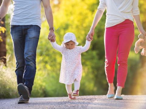 genitori che tengono per mano la figlia piccola per evocare il tema della natalità, al centro del report Istat Indicatori demografici. Anno 2023