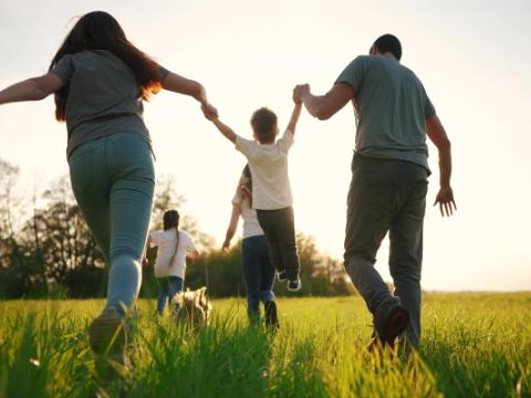 genitori e figli che corrono su un prato