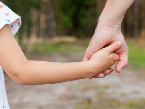 adulto che prende per mano una bambina