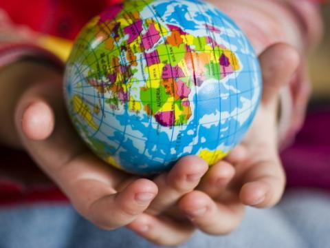 bambino che tiene in mano un piccolo mappamondo