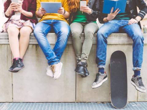 ragazze e ragazzi seduti su un muretto