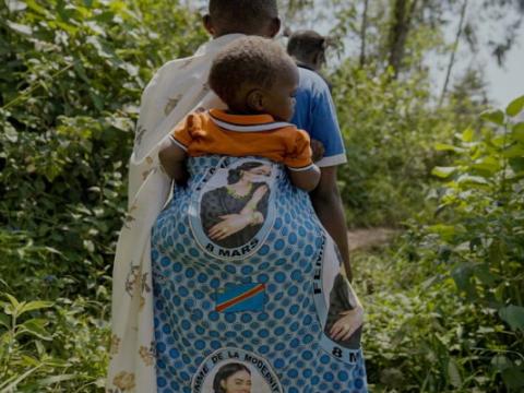 madre africana che porta sulle spalle il proprio bambino