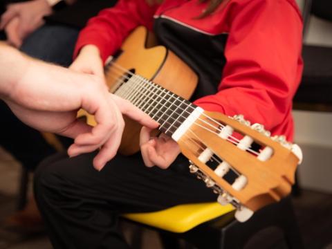 bambina che impara a suonare la chitarra
